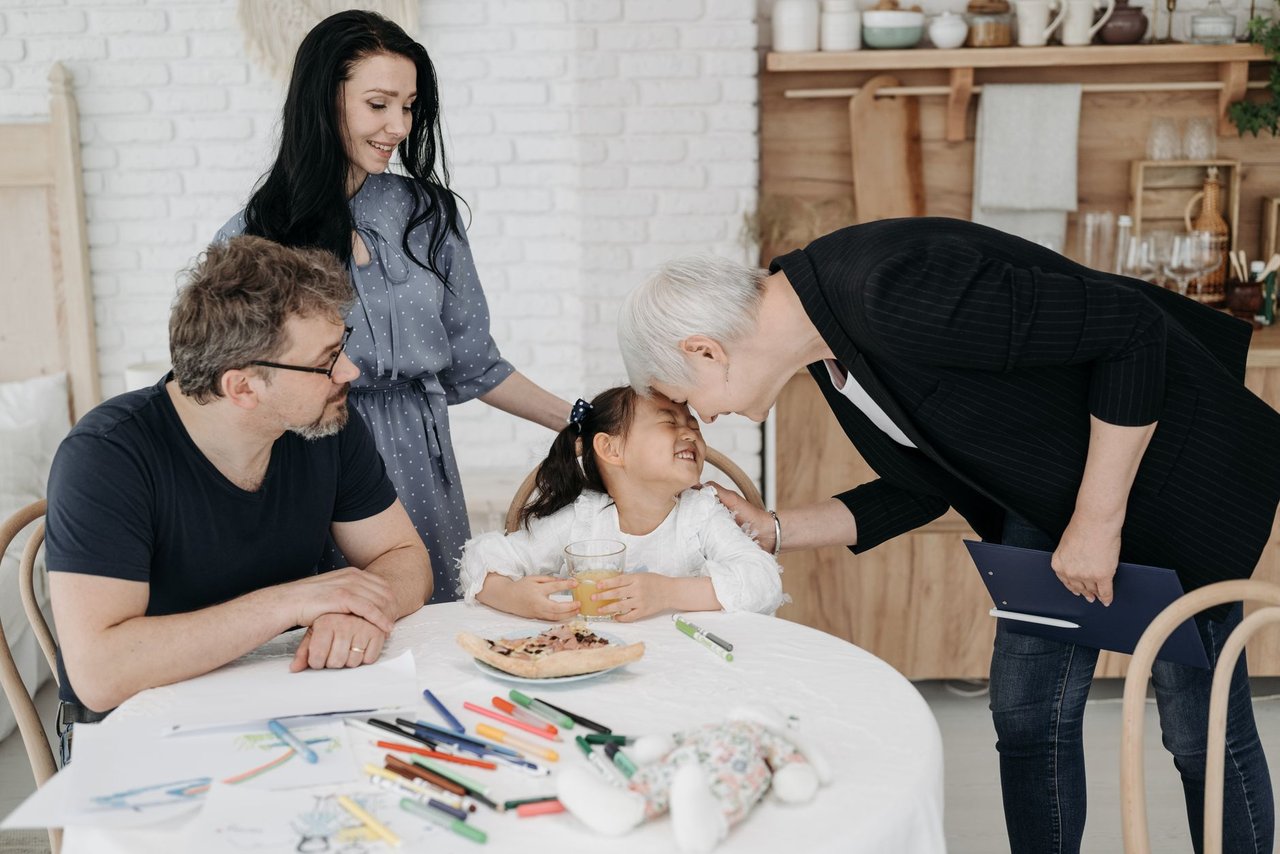 Família conversa com uma profissional de assistência social sobre questões relacionadas ao bem-estar infantil.