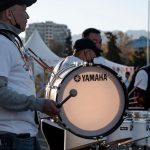 Músicos tocam tambores durante uma apresentação cultural ao ar livre, sob a luz do dia.